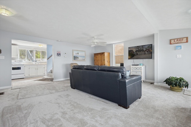 carpeted living room with ceiling fan, lofted ceiling, and sink