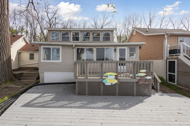 rear view of property featuring a sunroom and a deck