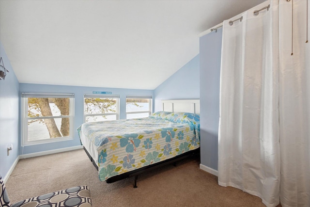 bedroom with multiple windows, light carpet, and vaulted ceiling