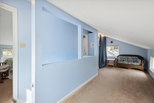 corridor with light carpet and lofted ceiling