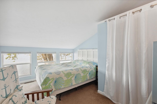 carpeted bedroom with lofted ceiling