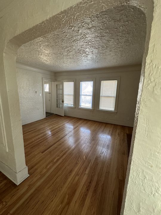 spare room with a textured ceiling and hardwood / wood-style flooring