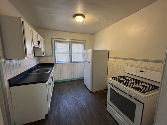 kitchen with white appliances, white cabinets, sink, dark hardwood / wood-style floors, and tile walls