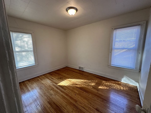 unfurnished room with wood-type flooring