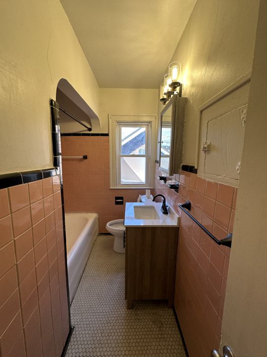 bathroom with tile patterned floors, vanity, tile walls, and toilet