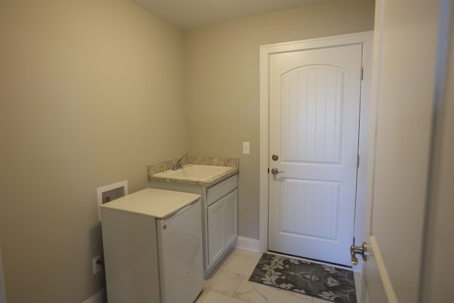 laundry room with hookup for a washing machine, sink, and cabinets