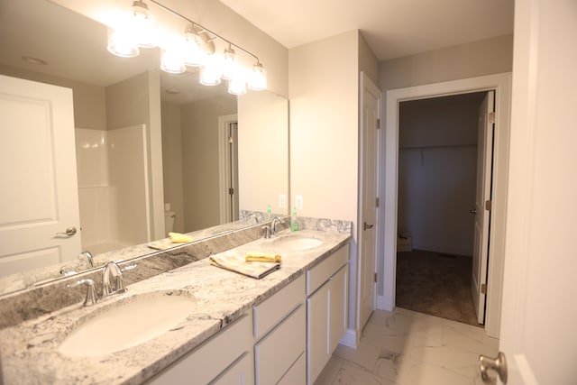 bathroom featuring a shower and vanity