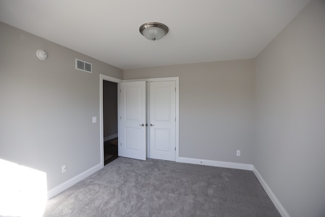 unfurnished bedroom with carpet flooring and a closet