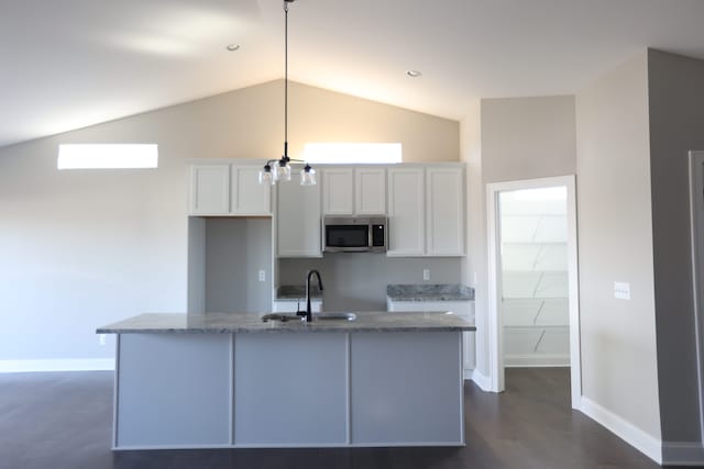 1012 Camellia Cir Unit 48, Howell, MI 48843 - kitchen with stainless steel microwave, a sink, white cabinetry, baseboards, and vaulted ceiling