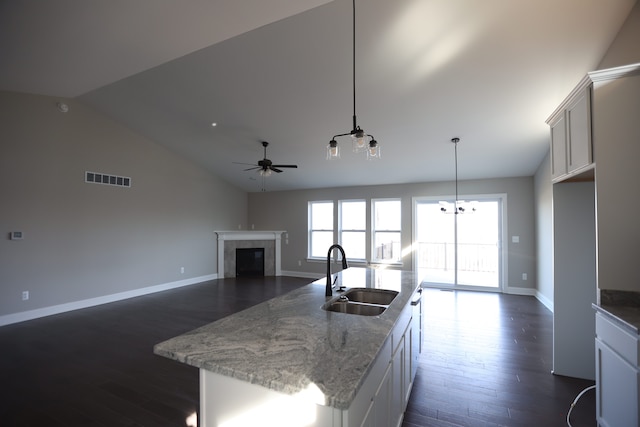 1012 Camellia Cir Unit 48, Howell, MI 48843 - kitchen with a sink, a tiled fireplace, lofted ceiling, dark wood-type flooring, and a ceiling fan