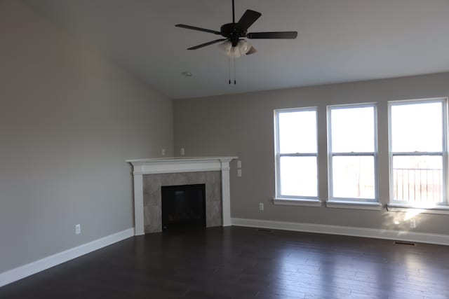 1012 Camellia Cir Unit 48, Howell, MI 48843 - unfurnished living room featuring dark wood-style flooring, vaulted ceiling, baseboards, a ceiling fan, and a tile fireplace