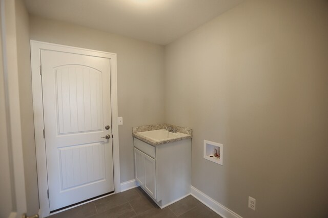 1012 Camellia Cir Unit 48, Howell, MI 48843 - laundry area featuring a sink, washer hookup, dark tile patterned floors, and baseboards