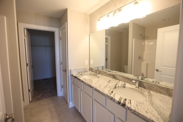 1012 Camellia Cir Unit 48, Howell, MI 48843 - bathroom featuring toilet, a shower, tile patterned floors, and double vanity