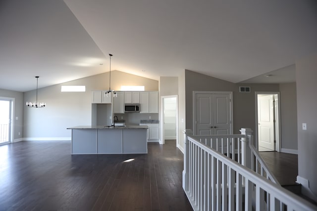 1012 Camellia Cir Unit 48, Howell, MI 48843 - kitchen featuring stainless steel microwave, lofted ceiling, baseboards, a chandelier, and white cabinets