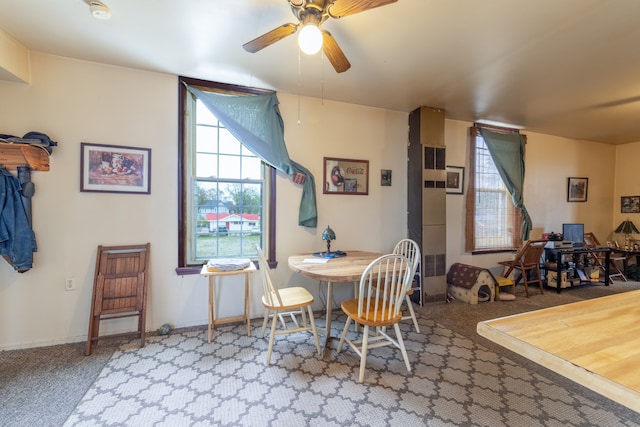 dining area with ceiling fan and carpet