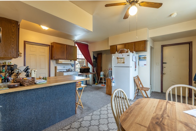 kitchen featuring kitchen peninsula, ceiling fan, light colored carpet, and white refrigerator