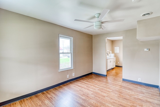 spare room with ceiling fan, light hardwood / wood-style flooring, and sink