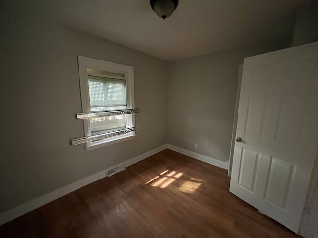 unfurnished room with dark hardwood / wood-style floors