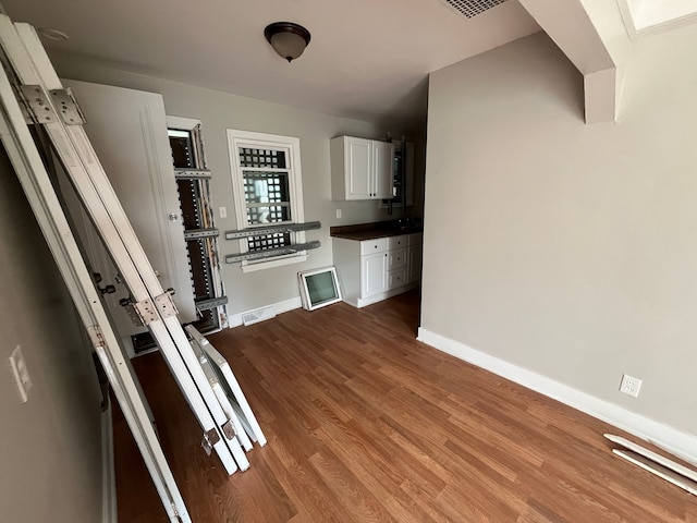 kitchen with hardwood / wood-style floors and white cabinetry