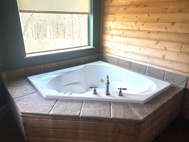 bathroom with a relaxing tiled tub