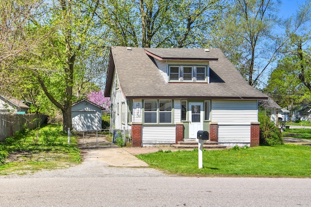 view of front of house featuring a front yard, a garage, and an outdoor structure