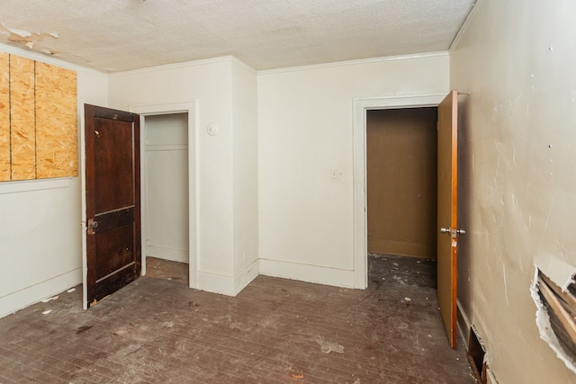 unfurnished bedroom with dark hardwood / wood-style floors, ornamental molding, a textured ceiling, and a closet