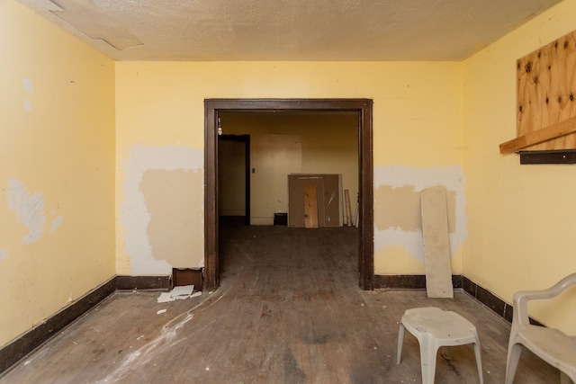 hall with dark wood-type flooring and a textured ceiling