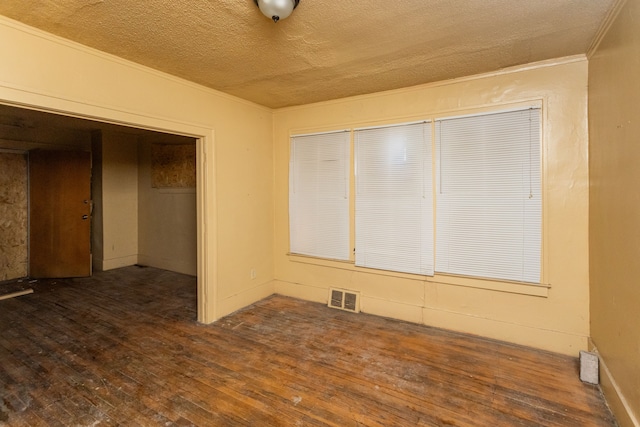 unfurnished bedroom featuring a textured ceiling, dark hardwood / wood-style floors, a closet, and crown molding