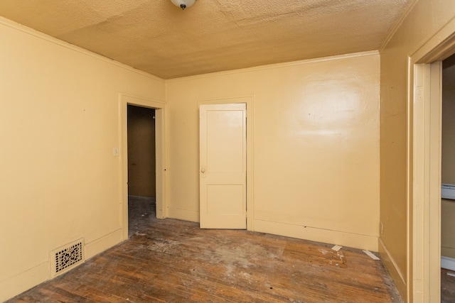 spare room with baseboard heating, crown molding, dark hardwood / wood-style flooring, and a textured ceiling