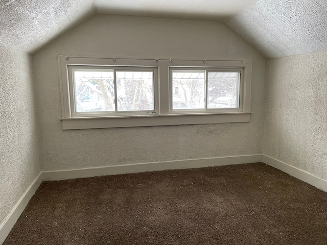 bonus room with carpet flooring, a textured ceiling, and lofted ceiling