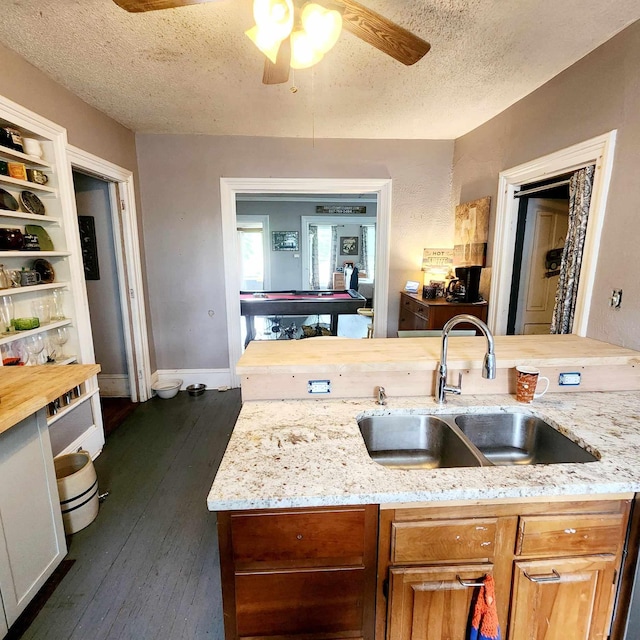 kitchen featuring wood counters, a textured ceiling, ceiling fan, sink, and dark hardwood / wood-style floors