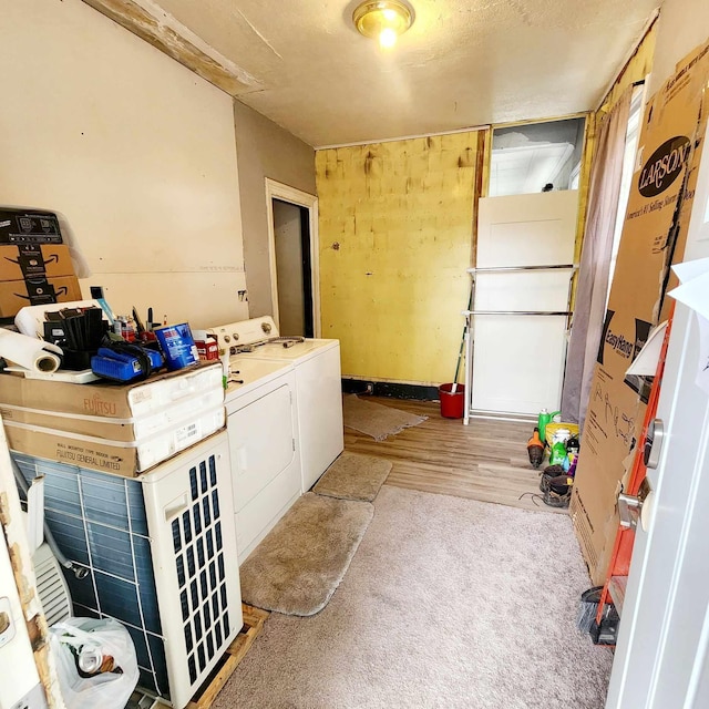 laundry room featuring washing machine and clothes dryer and light hardwood / wood-style floors