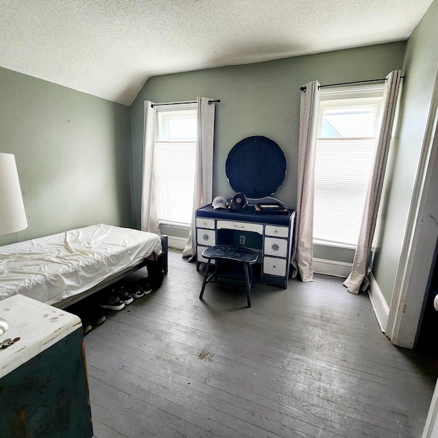 bedroom with hardwood / wood-style flooring, multiple windows, and lofted ceiling