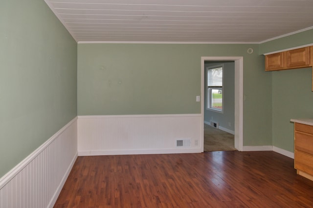 empty room featuring dark hardwood / wood-style flooring and crown molding