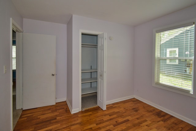 unfurnished bedroom featuring a closet and dark hardwood / wood-style flooring