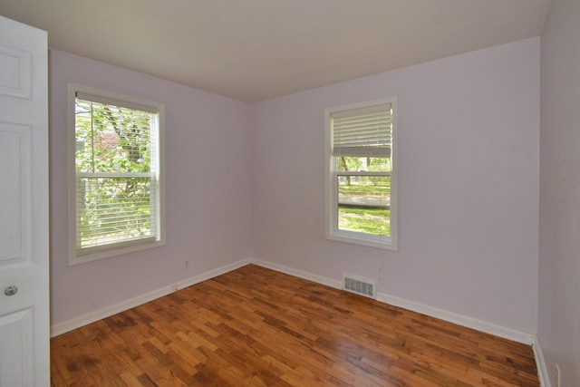 unfurnished room with wood-type flooring