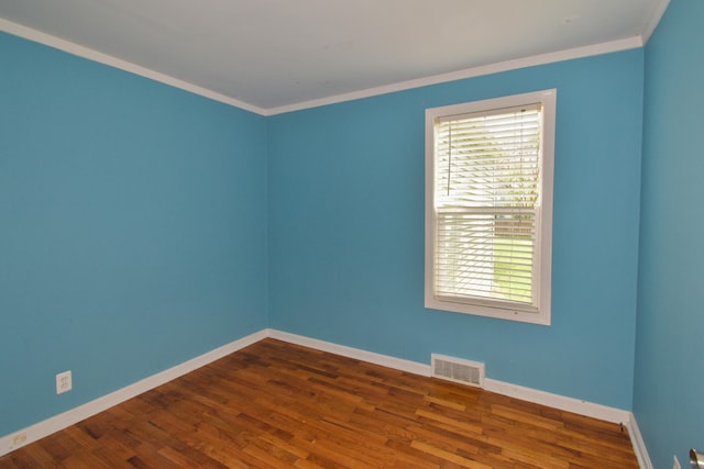 empty room featuring crown molding and dark wood-type flooring