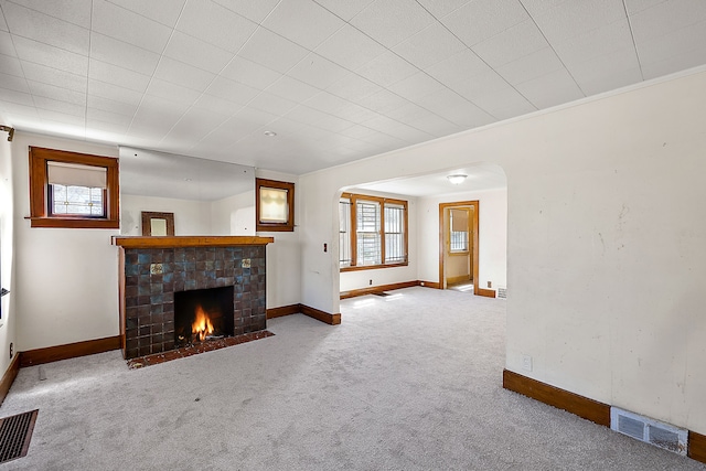 unfurnished living room with carpet flooring and a fireplace