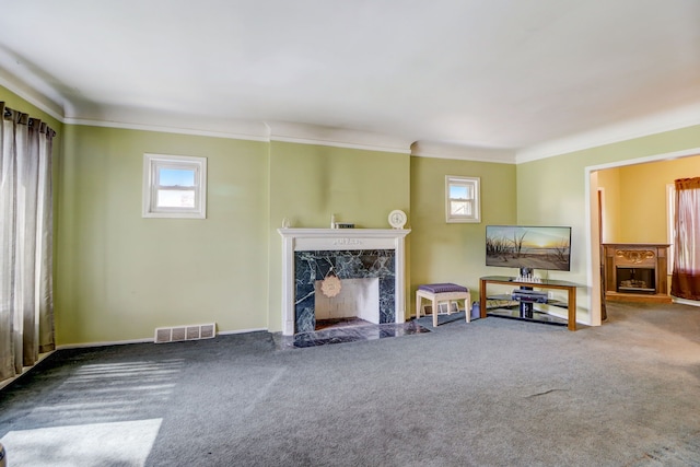 living room featuring a fireplace, crown molding, and a healthy amount of sunlight