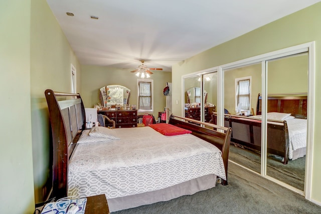 carpeted bedroom with ceiling fan and two closets