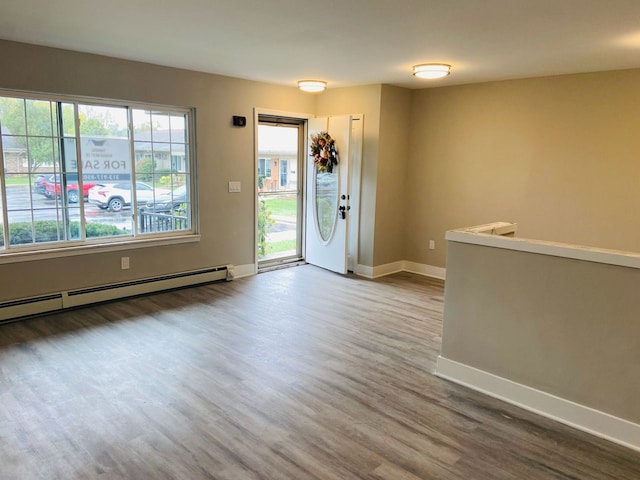 foyer entrance featuring wood-type flooring and a baseboard heating unit