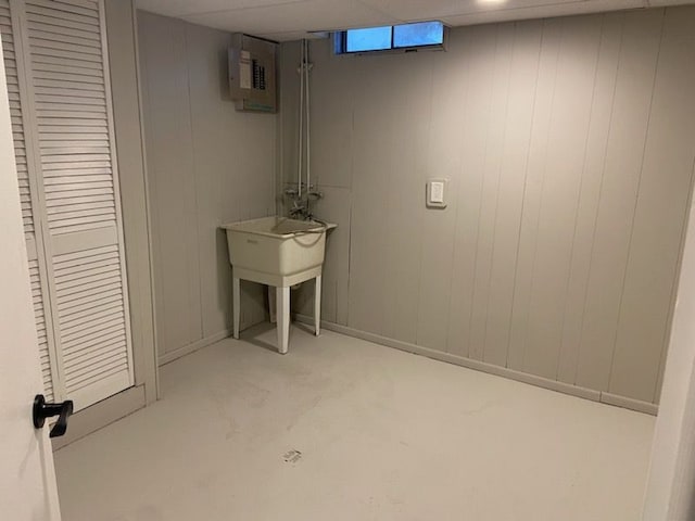 basement featuring electric panel and wood walls