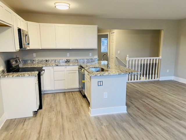 kitchen with white cabinets, sink, stainless steel appliances, and light hardwood / wood-style flooring