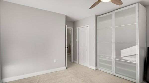 unfurnished bedroom with light colored carpet and ceiling fan