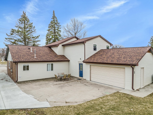 back of property featuring a patio area, a yard, and a garage