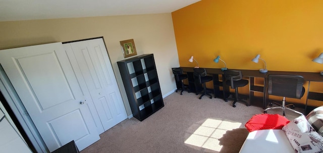 home office with lofted ceiling and light carpet