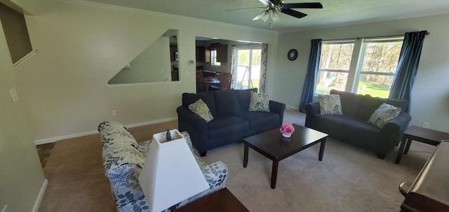 carpeted living room with crown molding, ceiling fan, and a healthy amount of sunlight