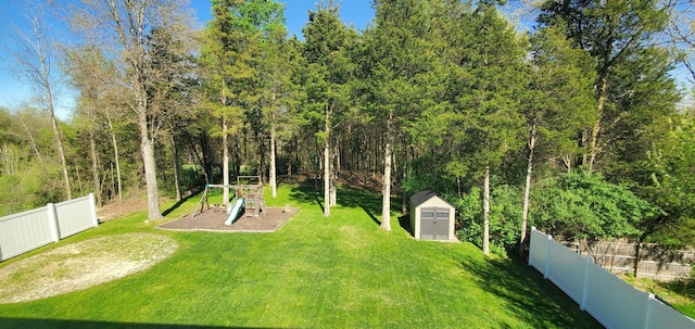 view of yard featuring a storage shed and a playground