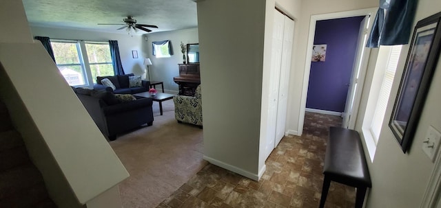 hall featuring carpet and a textured ceiling