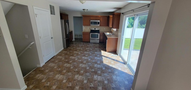 kitchen featuring decorative backsplash, sink, and appliances with stainless steel finishes